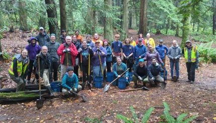 A large group of trail work volunteers in the woods