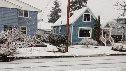 Residential street with snow on sidewalks and roads