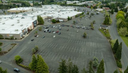 Aerial view of the Bellis Fair Mall showing a mostly empty parking lot during the day.