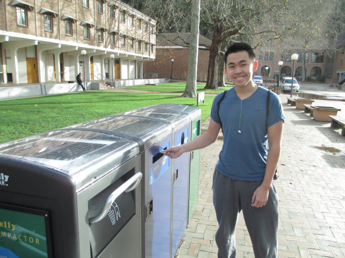 Student on Western's campus using a garbage and recycling disposal system.