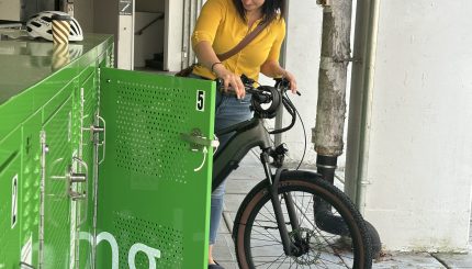 A woman puts a bicycle into a locker