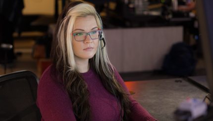 911 dispatcher with headset sitting at desk