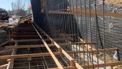 metal rebar and wood framing outdoors next to hill