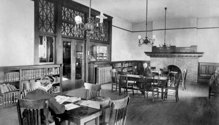 a historical photo of two men in a library reading