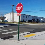 Stop sign and newly repaved and marked accessible curb
