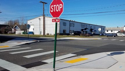 Stop sign and newly repaved and marked accessible curb