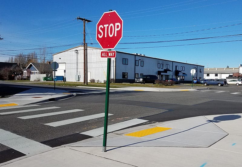 Stop sign and newly repaved and marked accessible curb