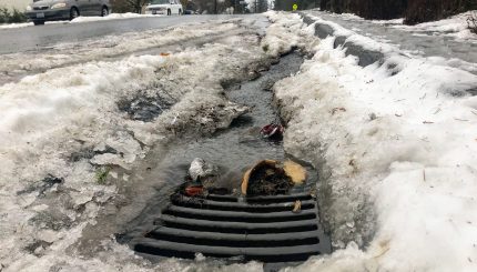 storm grate with slushy snow and runoff