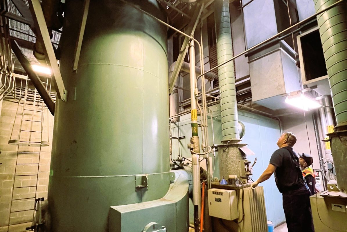 industrial looking indoor setting with large pipes and worker