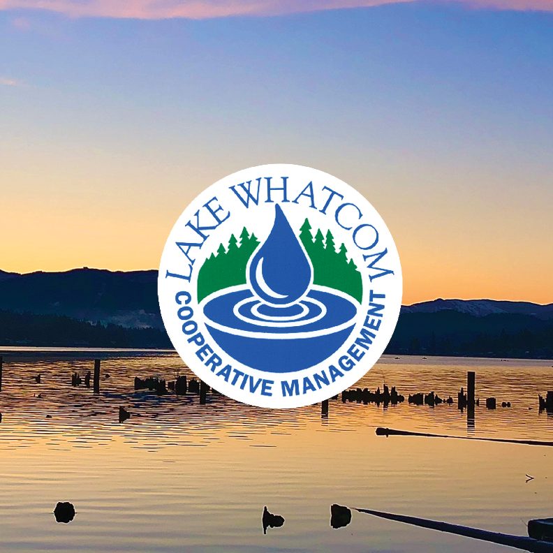 Lake Whatcom Cooperative Management logo with a blue water droplet. Sunset over Lake Whatcom in the background.