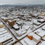 Aerial photo of snow covered downtown Bellingham buildings with snowy, treed hills in distance