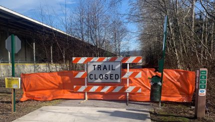 Trail closed sign with safety fence