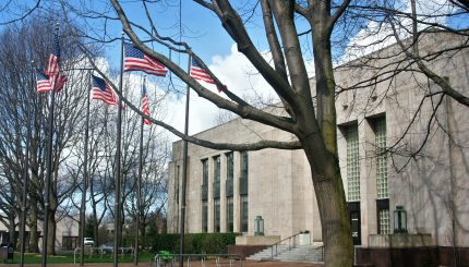 Bellingham City Hall and four American flags in the pavilion in front.