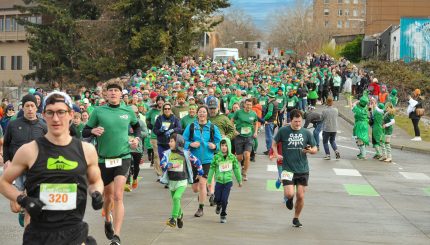Hundreds of Runnin' O' the Green Participants race from the start of the annual event.
