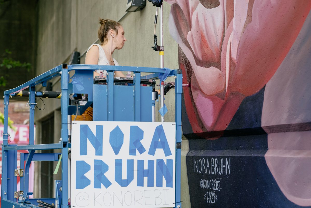 Pink peonies against a dark blue background painted on the Railroad Avenue Parking Garage.