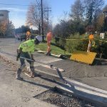 Worker using tool to flatten wet cement for new sidewalk