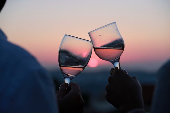 Two wine glasses with sunset in background