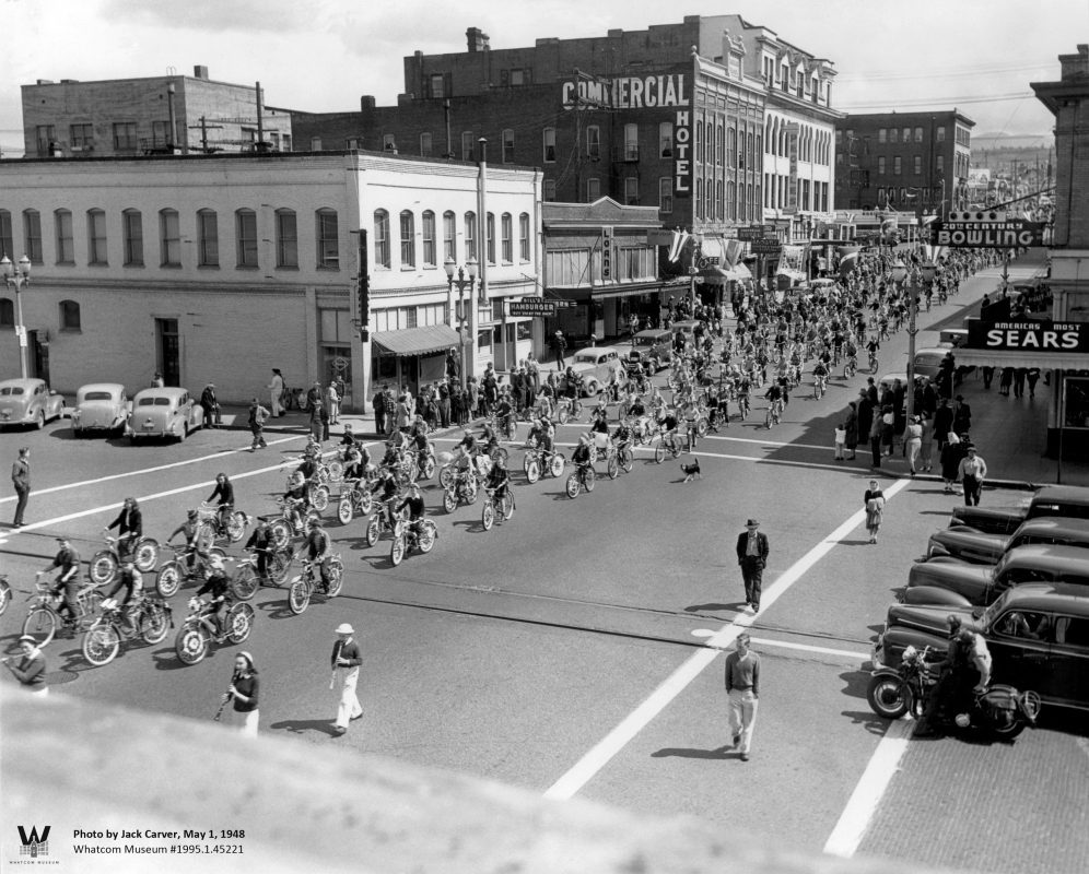 Black and white photo showing hundreds of bicyclists riding down a street in 1948.