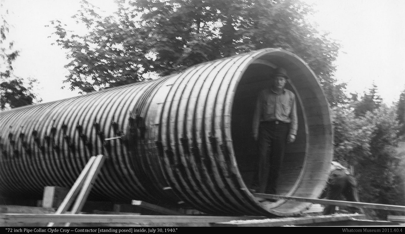 Contractor standing inside 72 inch diameter wood stave pipe prior to installation.