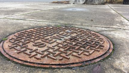 close-up metal sewer cover on Woburn Street