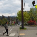 Person walking through hashed crosswalk with flashing light