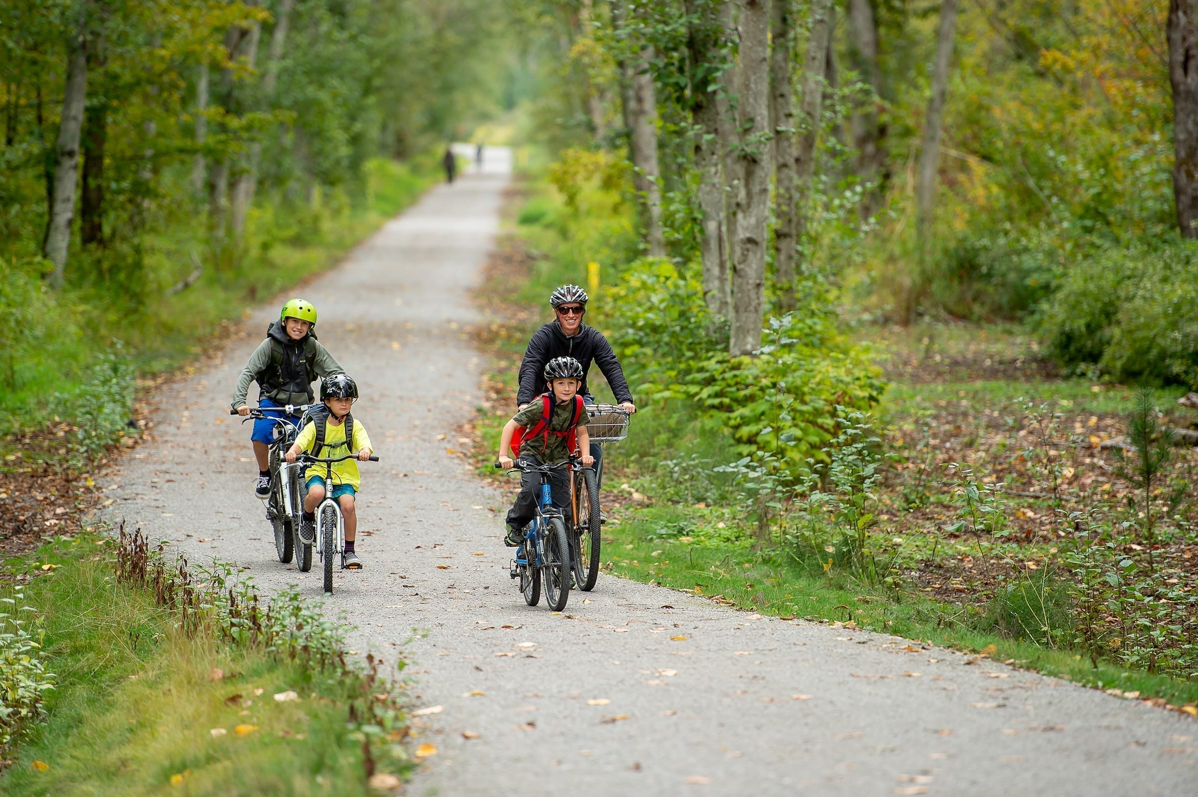 Family of four biking on trail