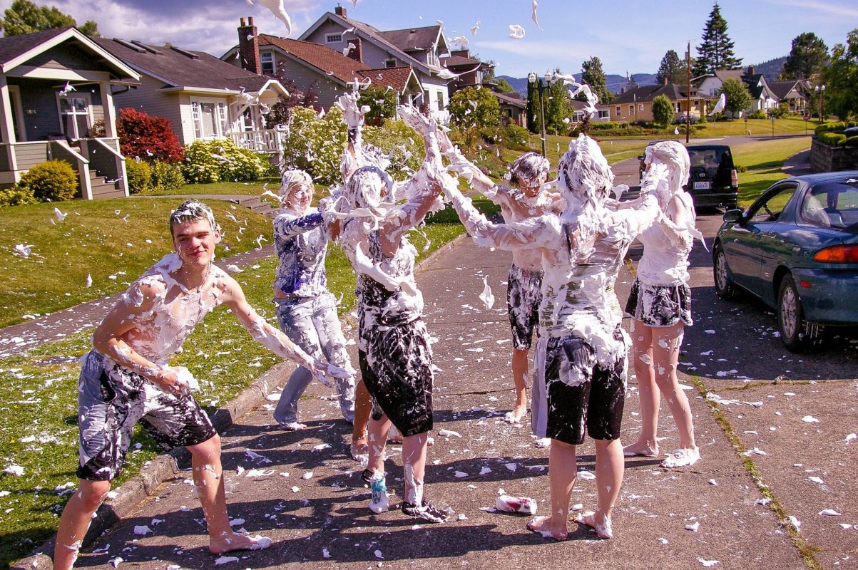 Youth covered in shaving cream on a neighborhood street