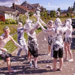Youth covered in shaving cream on a neighborhood street