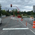 Temporary traffic lights over bridge with line in road and "stop here on red" sign