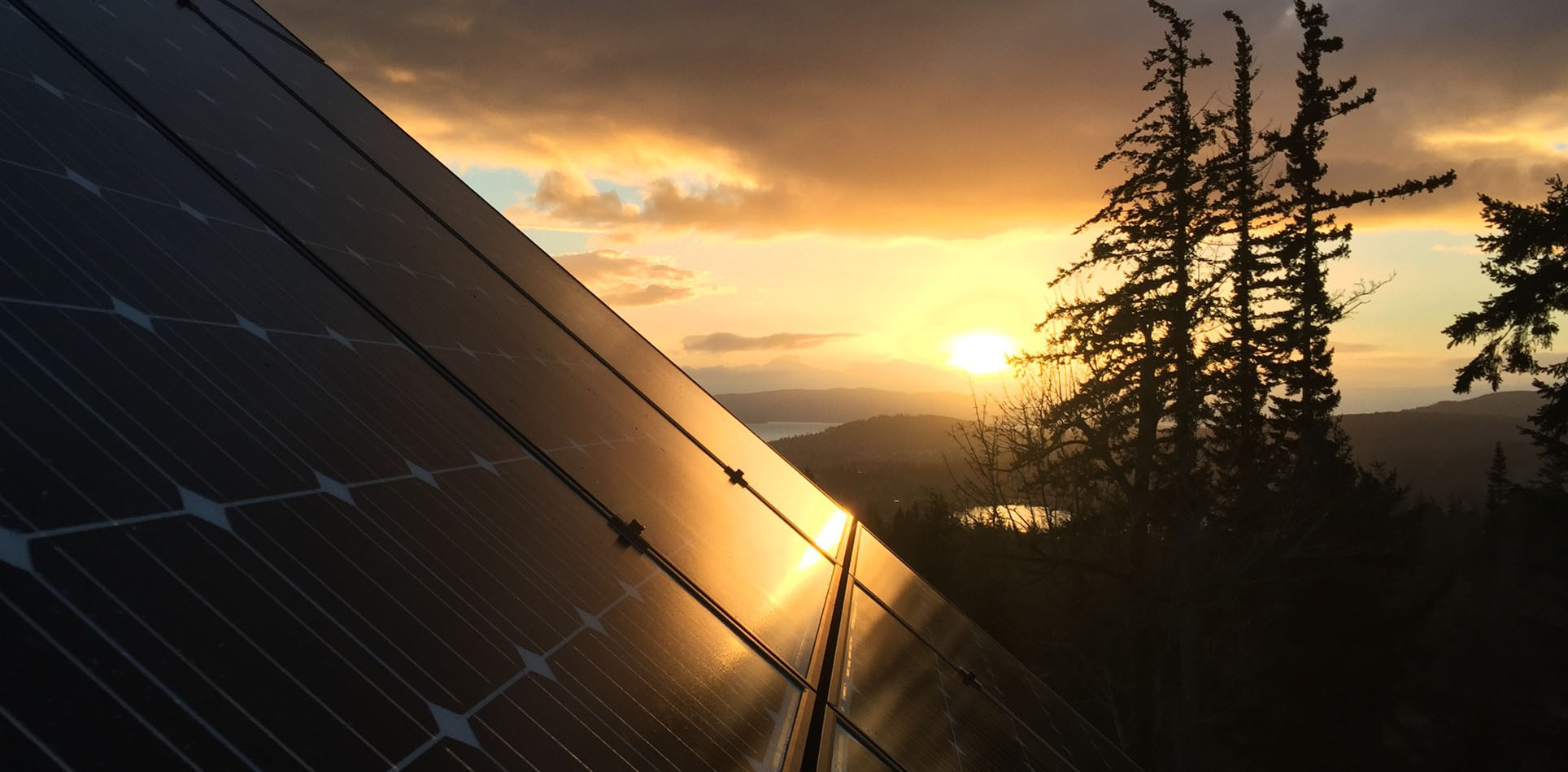 Sunset in the background, solar panel array in the foreground